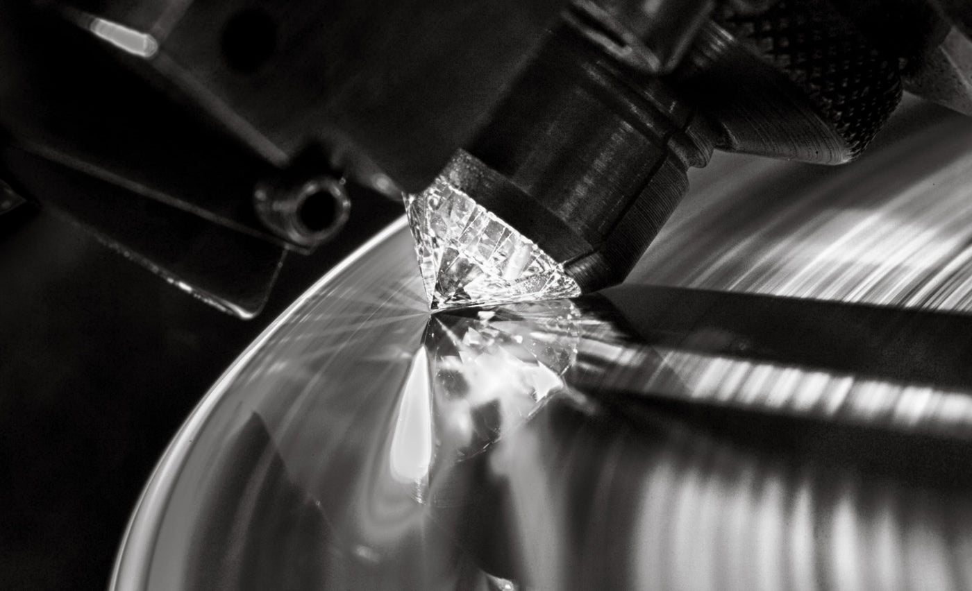 lab grown diamond getting cut in machine sparkles & reflects on the metal
