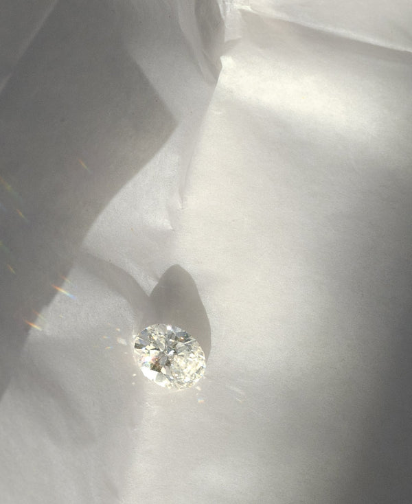 lab grown oval diamond sparkles as light hits it on white paper