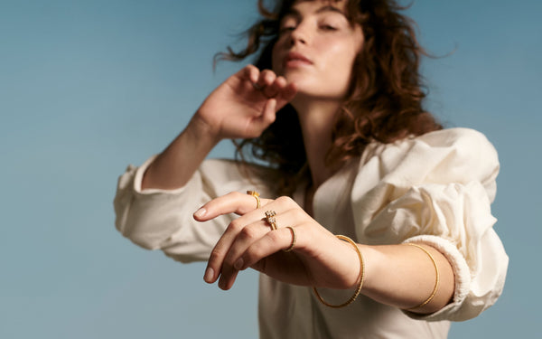 girl wears 2 filigree bracelets 2 beaded rings 1 filigree emerald cut ring of lab grown diamonds & 18k recycled gold jewelry