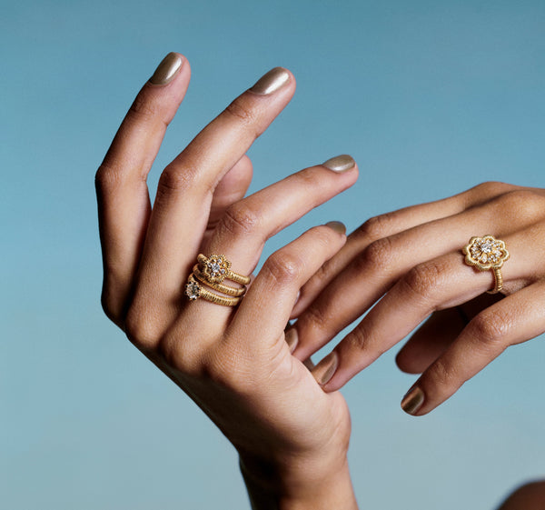2 hands wear lace flower rings w/ 1 beaded ring & 1 filigree ring of lab grown diamonds & 18k recycled yellow gold for oscar massin jewelry