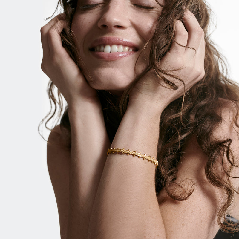 Oscar Massin woman wearing recycled yellow gold beaded bracelet