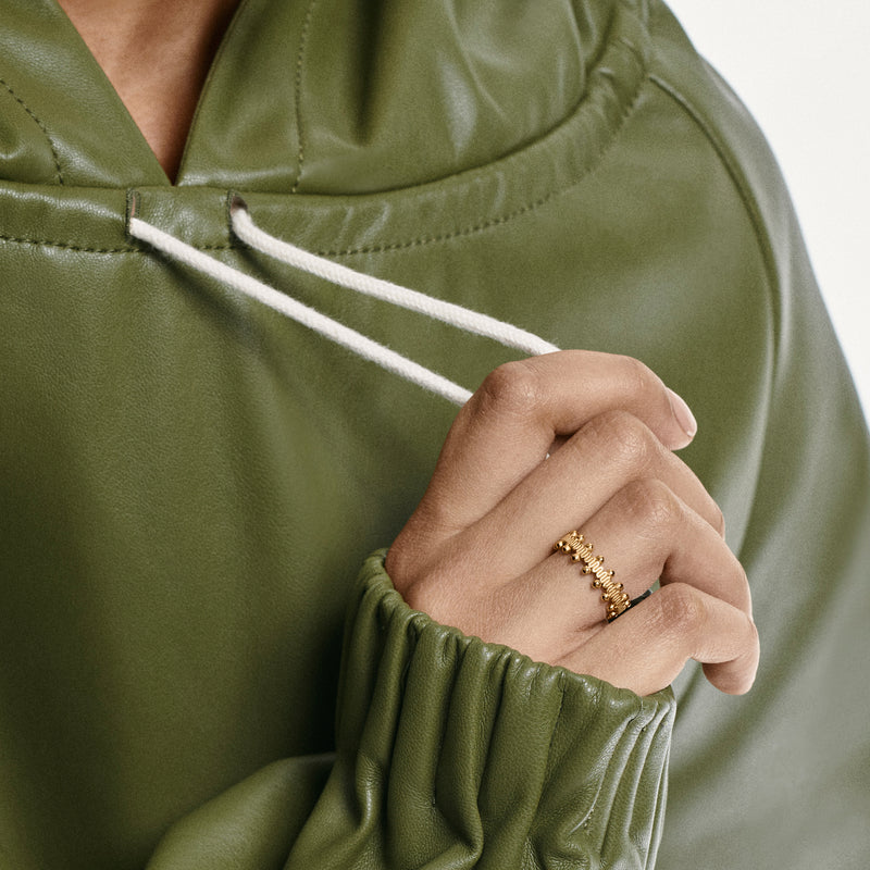 Woman wearing an Oscar Massin filigree ring made of recycled yellow gold