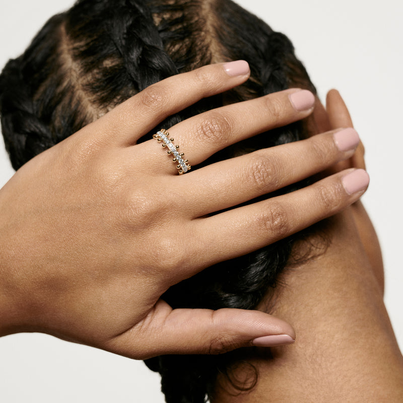 Woman wearing Oscar Massin beaded ring made of 18K recycled yellow gold and set with lab grown and conflict-free diamonds