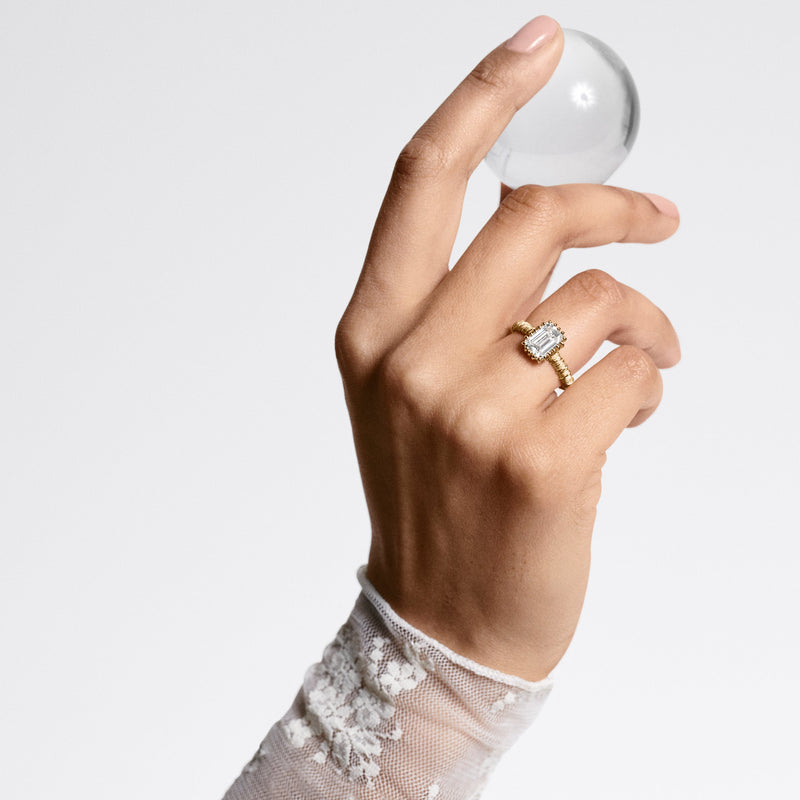 Woman wearing Oscar Massin filigree ring in recycled yellow gold and topped by a sustainable lab grown diamond